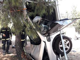 Un coche acaba vertical tras salirse de una rotonda y chocar contra un pino