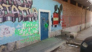 El local, con pintadas y la máscara en la puerta.