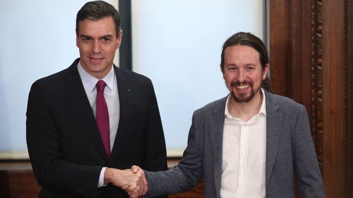 El presidente del Gobierno en funciones, Pedro Sánchez (izq) y el secretario general de Podemos, Pablo Iglesias (dech), se dan la mano durante el acto de presentación del programa de Gobierno del PSOE y Unidas Podemos.