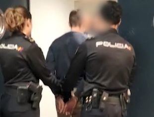 Agentes de Policía Nacional conducen a uno de los detenidos por robar un coche e intentar atropellar a los agentes.