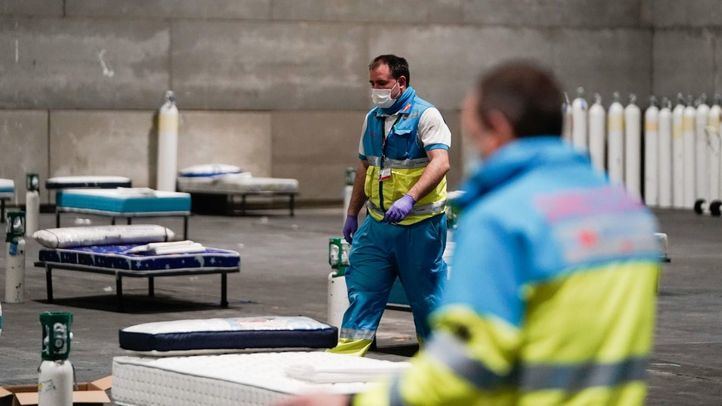 Miembros del SUMMA colocando camas en los pabellones de Ifema