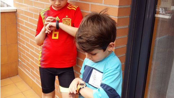 Dos niños comprueban sus pasos en sus podómetros