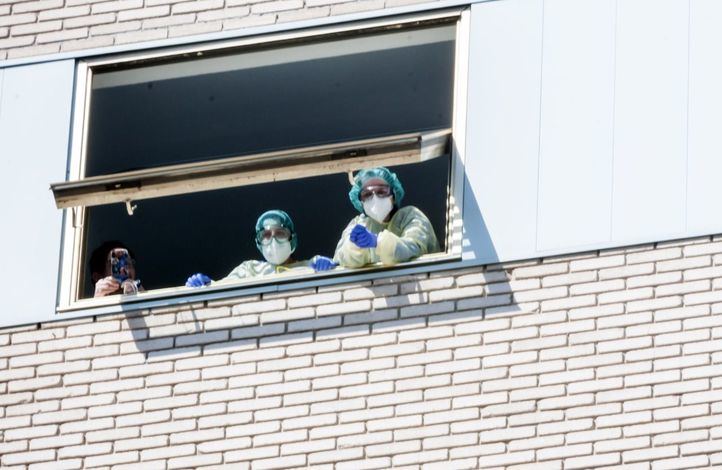 Unos enfermos desde la ventana del hospital.