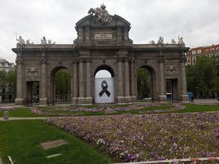 Un lazo negro en la Puerta de Alcalá recuerda a los fallecidos por COVID-19