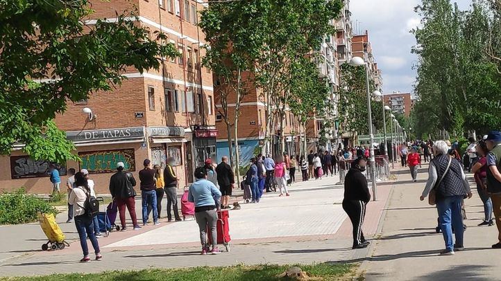Centenares de personas hacen cola cada fin de semana para recoger alimentos en un local de Asociación de Vecinos de Aluche.