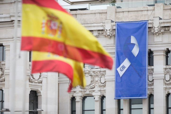 Bandera de España en la Fuente de Cibeles y bandera con el lazo que simboliza la lucha unida del pueblo de Madrid.