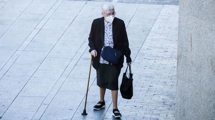Mujer mayor con mascarilla paseando en Gran Vía