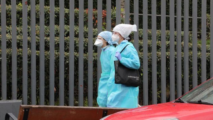 Dos trabajadoras protegidas pasean al lado de una residencia. [Imagen de archivo]