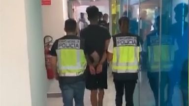 Dos agentes de la Policía con uno de los detenidos