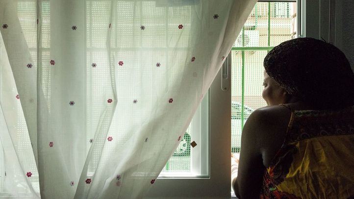 Mujer asomada a una ventana