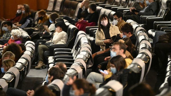 Gente con mascarilla en un teatro.
