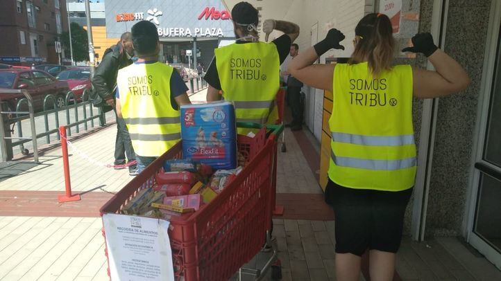 Tres voluntarios de la red de apoyo vecinal colaboran en el reparto de alimentos.