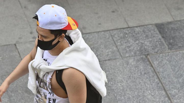 Joven paseando por Gran Vía con la mascarilla