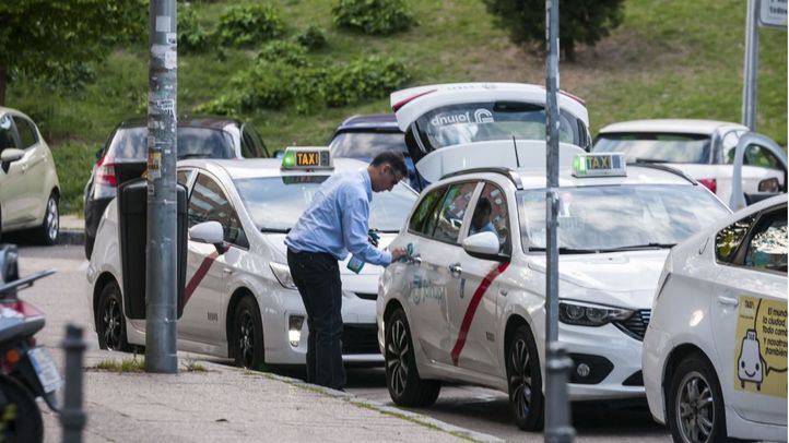 Taxista desinfectando su vehículo en la plaza de Cristo Rey.