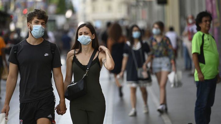 Dos peatones paseando con mascarilla