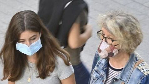 Dos mujeres caminan con mascarillas puestas