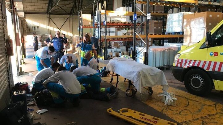 Foto de archivo: sanitarios atendiendo a un hombre herido por un accidente laboral