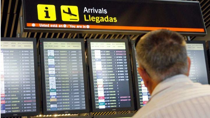 Hombre mirando pantallas de llegadas en el aeropuerto de Barajas