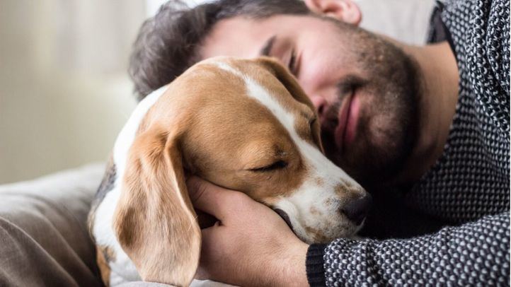 Hombre abrazado a su perro
