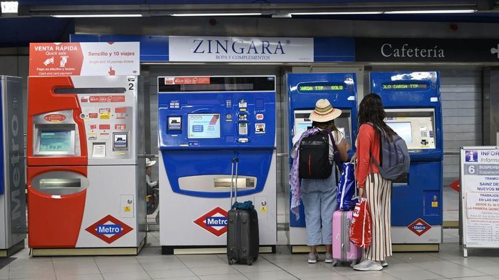 Dos turistas sacan billetes en las máquinas de Metro