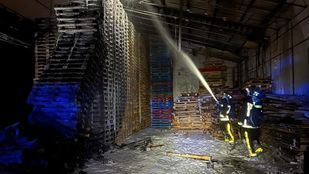 Bomberos apagan el fuego en una nave de palets en Torrejón