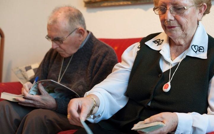Mayores con el botón de la teleasistencia colgado.