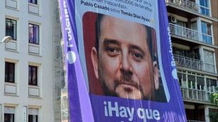 El PP de Ayuso denuncia a Podemos ante la Junta Electoral y exige retirar la lona con el tuit de Casado