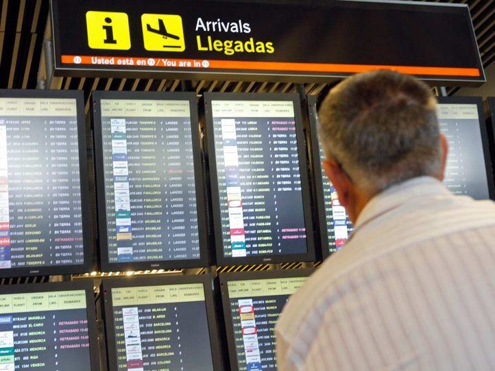 Hombre mirando pantallas de llegadas en el aeropuerto de Barajas