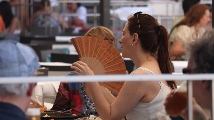 Una mujer se abanica en una terraza de Madrid