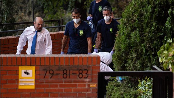Varias personas sacan uno de los cadáveres del domicilio en el que fueron encontrados, a 17 de agosto de 2023, en Moratalaz