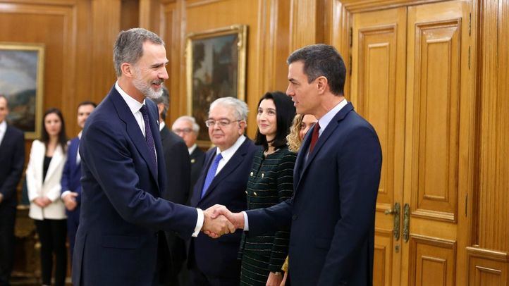 El Rey Felipe VI junto al presidente en funciones, Pedro Sánchez, durante el acto de promesa de cargos del Gobierno de coalición.