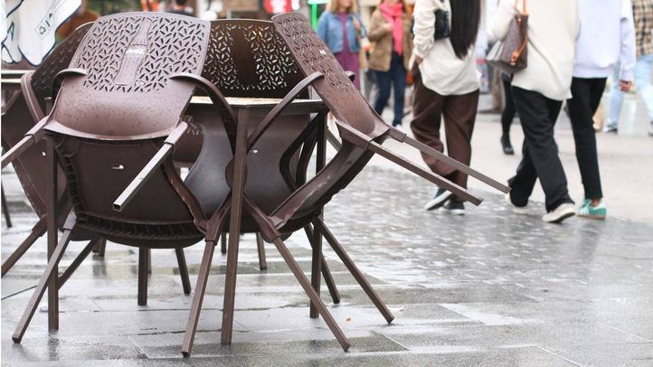 Sillas de terraza recogidas por la lluvia