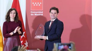 La presidenta de la Comunidad de Madrid, Isabel Díaz Ayuso, entrega un reconocimiento al hijo del investigador César Nombela, durante la presentación de las ayudas para la atracción del talento investigador de la Comunidad de Madrid, en la Facultad de Farmacia de la Universidad Complutense