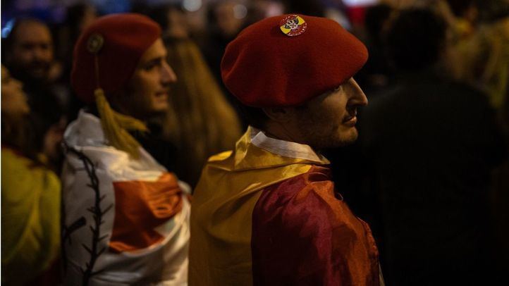 Dos manifestantes con banderas y chapelas, durante una manifestación contra la amnistía frente a la sede del PSOE en Ferraz, a 16 de noviembre