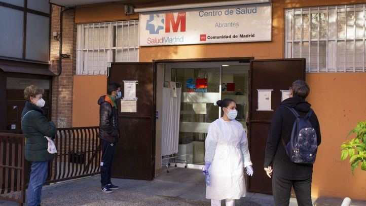 Gente con mascarilla ante un centro de salud