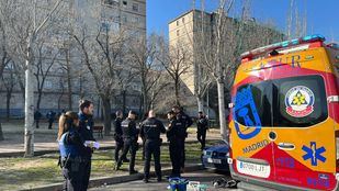 Sanitarios atienden a un hombre herido al caer al suelo cuando se deslizaba por una atadura de ropa por la fachada de un edificio de Puente de Vallecas