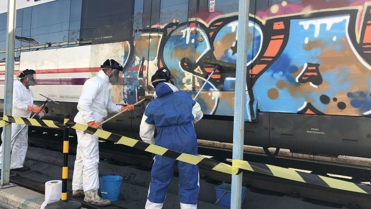 Operarios limpian un grafiti en un tren de Cercanías de Madrid, en una foto de archivo