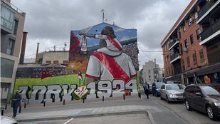 Un hombre espera junto a un gran mural conmemorativo con el año de la fundación del Rayo Vallecano