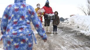 Una familia va a buscar provisiones en el Sector 6 de la Cañada Real tras el paso de Filomena