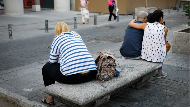 Una mujer sentada sola en un banco