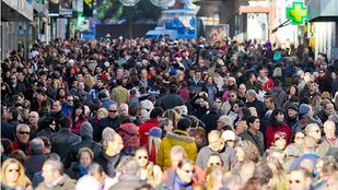 Gente en multitud va de compras navideñas por calle Preciados