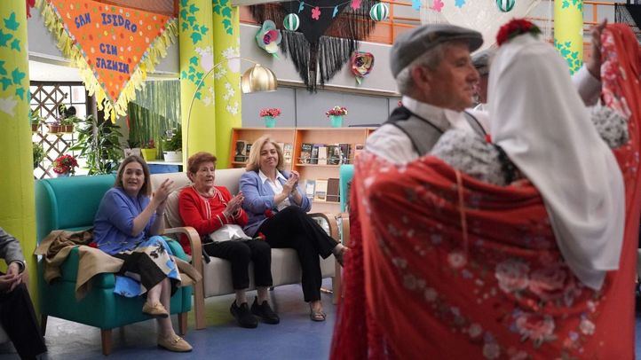 Inma Sanz, junto a Marta Rivera de la Cruz, José Fernández y Nadia Álvarez, acompaña a los usuarios de la Residencia Municipal de Mayores con Alzheimer Jazmín durante la actuación de la Federación de Grupos Tradicionales Madrileños por San Isidro