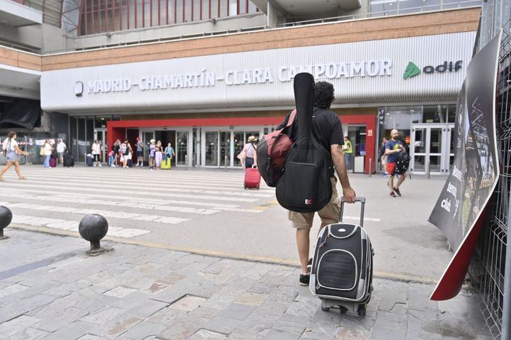 Joven con maleta llega a la estación.