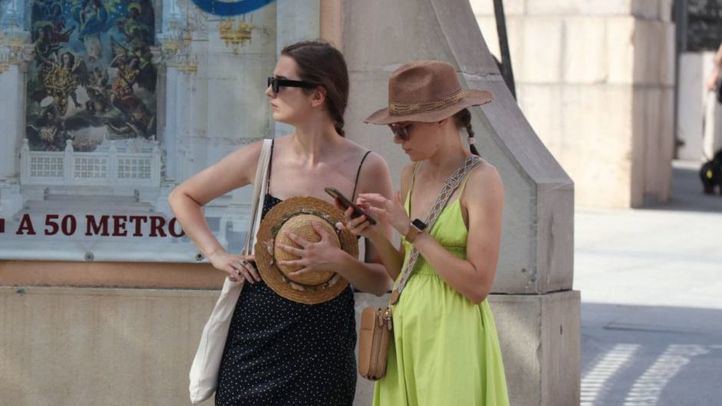 Turistas con sombrero para combatir el calor en Madrid