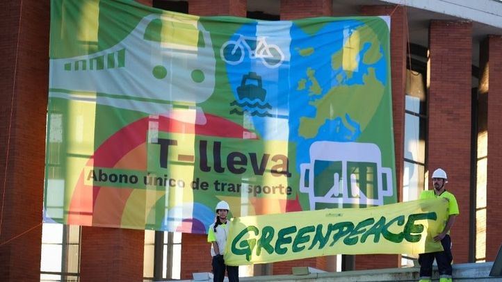 Greenpeace despliega una pancarta gigante en Atocha (Madrid) para reclamar un abono único de transportes.
