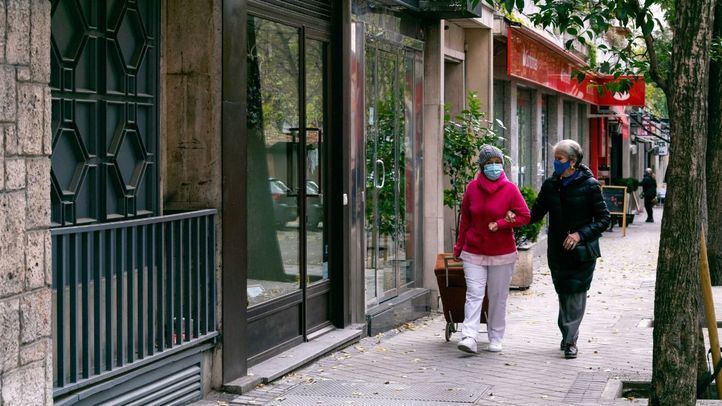 Dos mujeres caminan abrigadas por Madrid