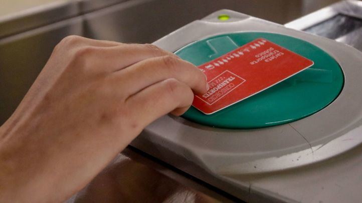 Una persona valida su abono en los tornos de entrada del metro