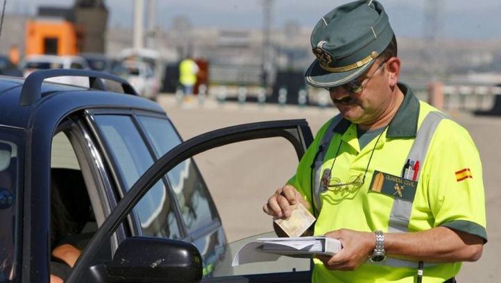 Agente de la Guardia Civil revisa la documentación de un vehículo.