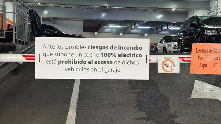 Parking público con cartel que prohíbe la entrada a coches eléctricos