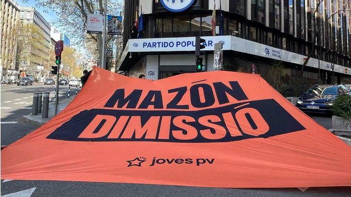 Las juventudes de Compromís despliegan en 'Génova' una gran pancarta para pedir la dimisión de Mazón